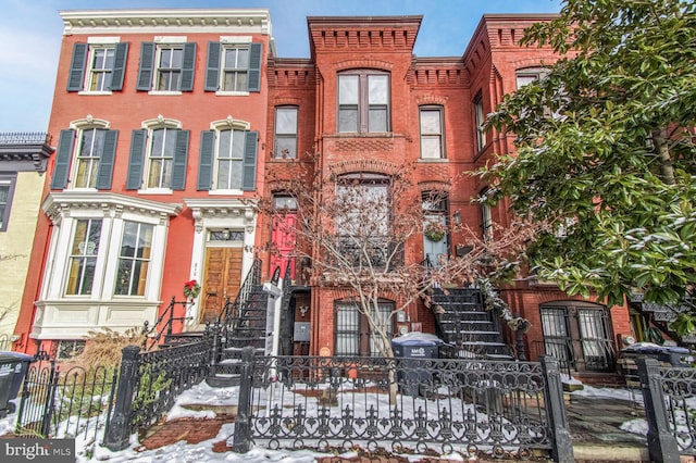 view of front of home featuring a fenced front yard and brick siding