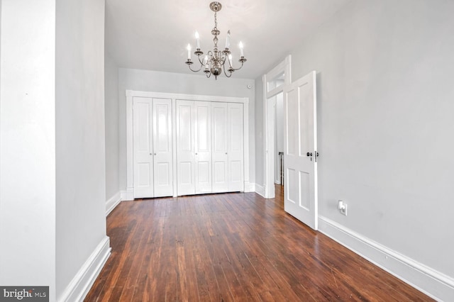 interior space featuring a chandelier, baseboards, and hardwood / wood-style flooring