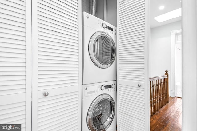 laundry room with laundry area, wood finished floors, and stacked washer / drying machine