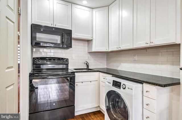 kitchen featuring black appliances, washer / dryer, white cabinetry, and a sink