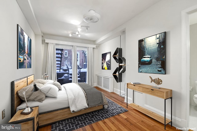 bedroom with hardwood / wood-style flooring and baseboards