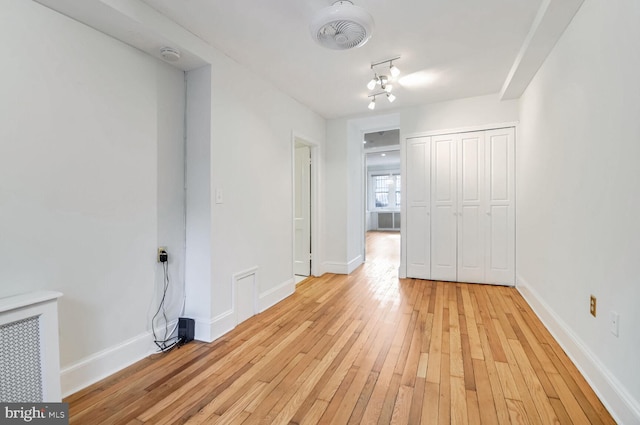 empty room featuring visible vents, light wood-style flooring, and baseboards