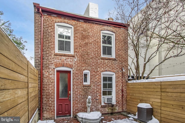 multi unit property featuring fence, cooling unit, and brick siding