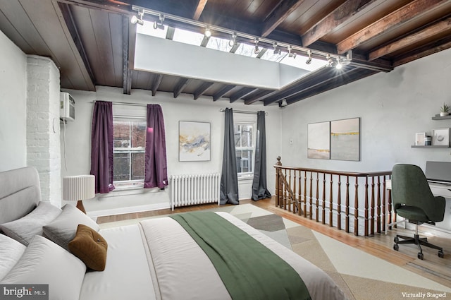 bedroom with wood ceiling, radiator, track lighting, and wood finished floors