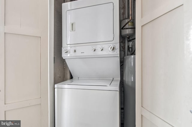 clothes washing area with stacked washer and dryer and laundry area