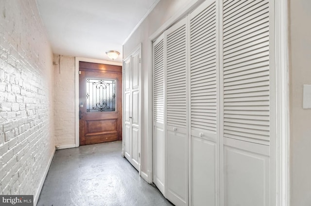 corridor featuring concrete floors and brick wall