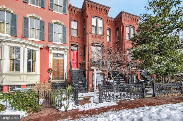 view of property featuring a fenced front yard and brick siding