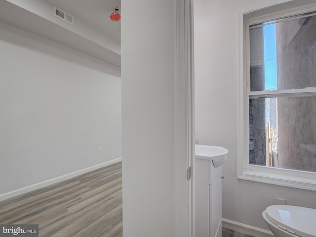 bathroom with hardwood / wood-style flooring, vanity, and toilet