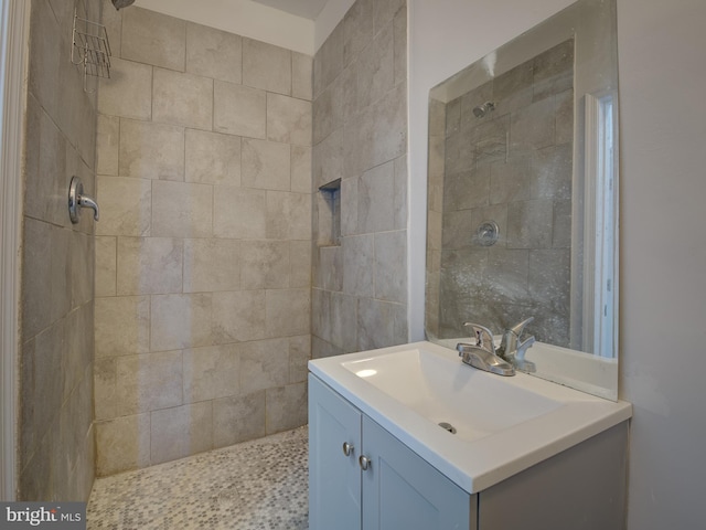 bathroom featuring tiled shower and vanity