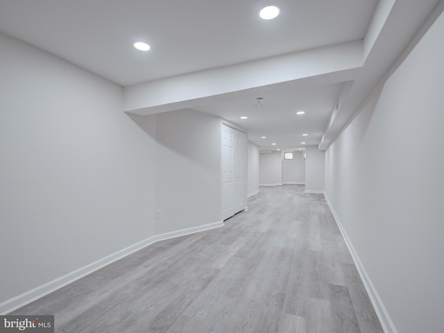 basement with light hardwood / wood-style flooring