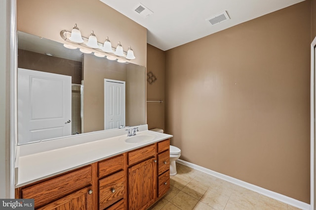 bathroom featuring vanity, tile patterned flooring, a shower with door, and toilet