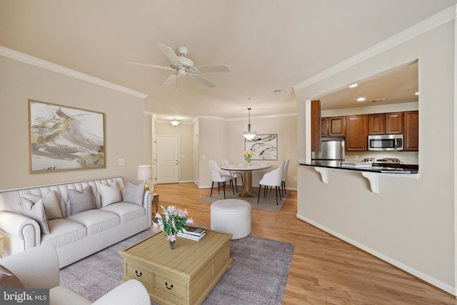 living room featuring crown molding, ceiling fan, and light hardwood / wood-style floors