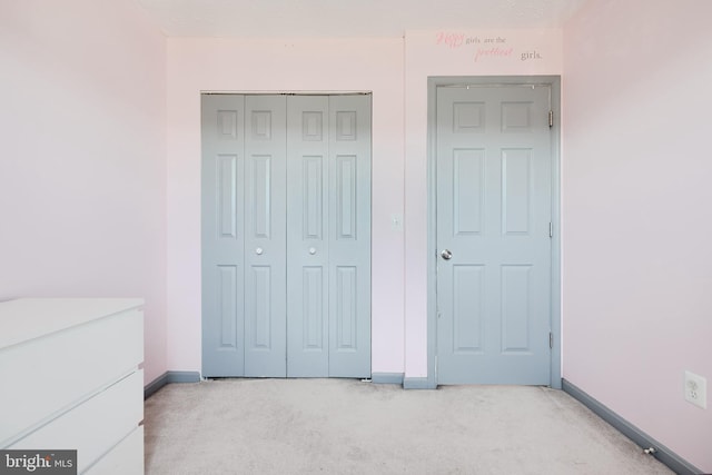 bedroom with light colored carpet and a closet