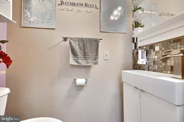 bathroom featuring backsplash, vanity, and toilet