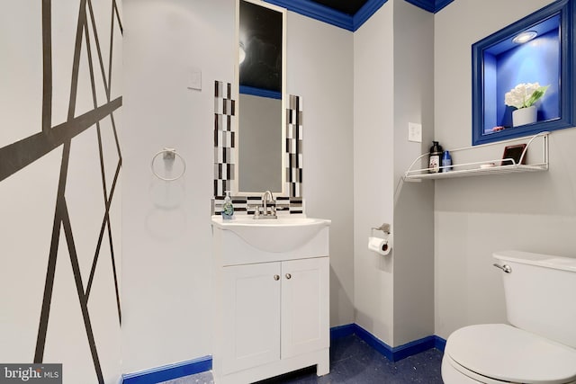 bathroom with vanity, toilet, and ornamental molding