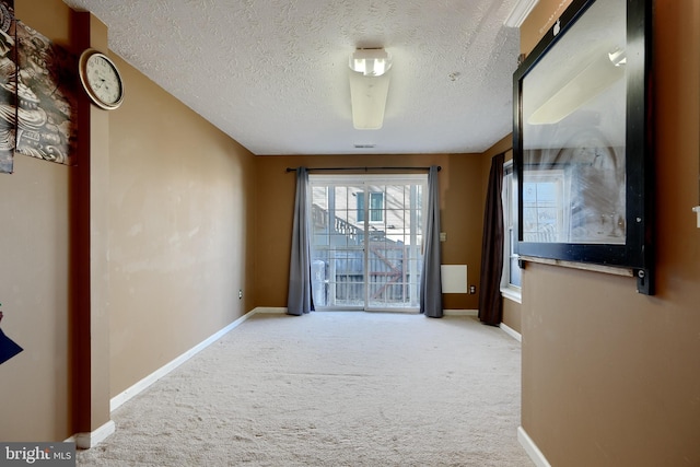 interior space featuring light carpet and a textured ceiling