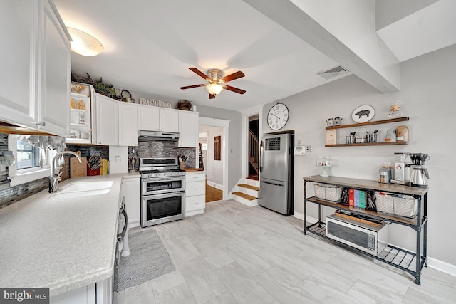 kitchen featuring white cabinets, appliances with stainless steel finishes, open shelves, and a sink