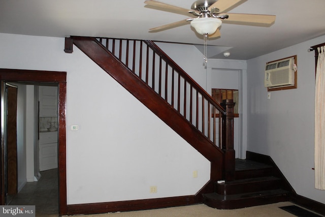 stairs featuring a wall unit AC and ceiling fan