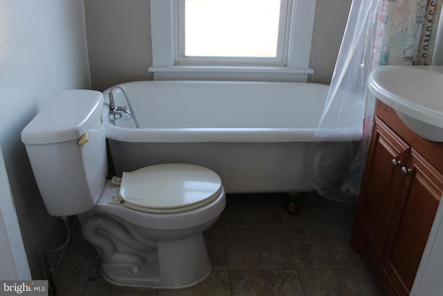 bathroom with tile patterned floors, a bathing tub, vanity, and toilet