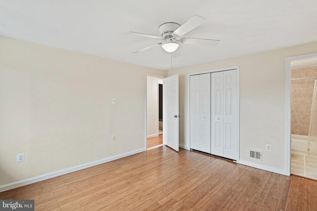 unfurnished bedroom featuring ensuite bath, ceiling fan, a closet, and light hardwood / wood-style floors