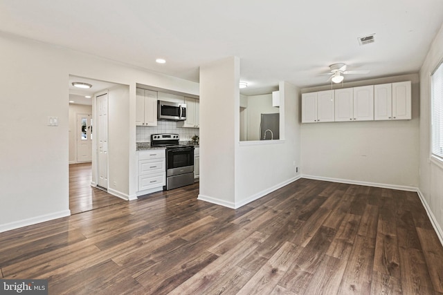 kitchen featuring appliances with stainless steel finishes, tasteful backsplash, ceiling fan, dark wood-type flooring, and white cabinets