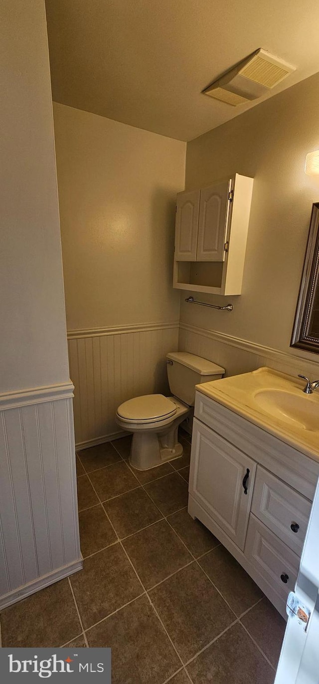 bathroom featuring tile patterned flooring, vanity, and toilet