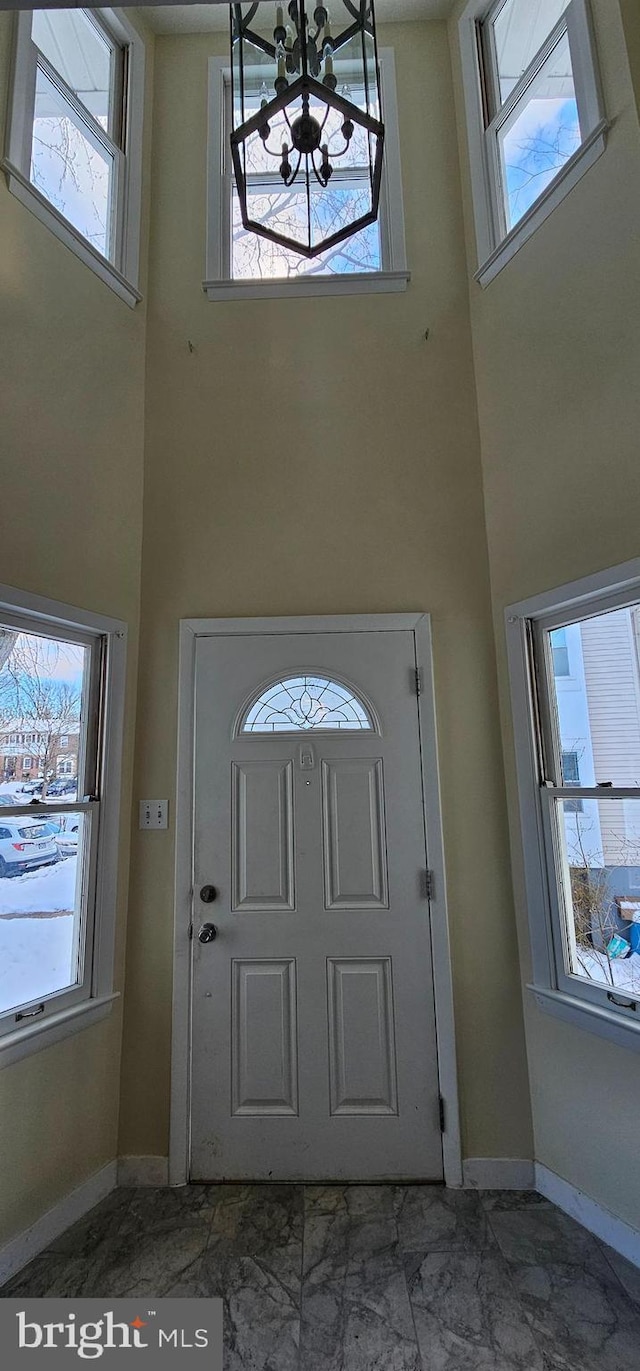 entryway featuring a towering ceiling and an inviting chandelier