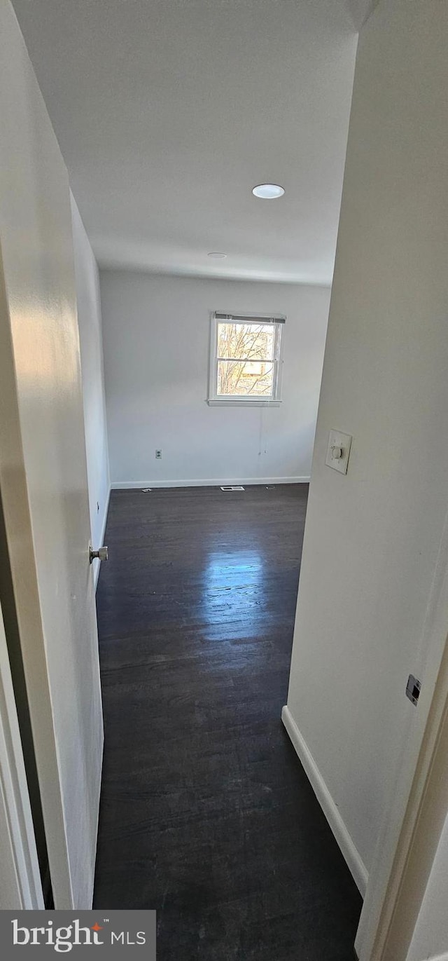 unfurnished room featuring dark wood-type flooring