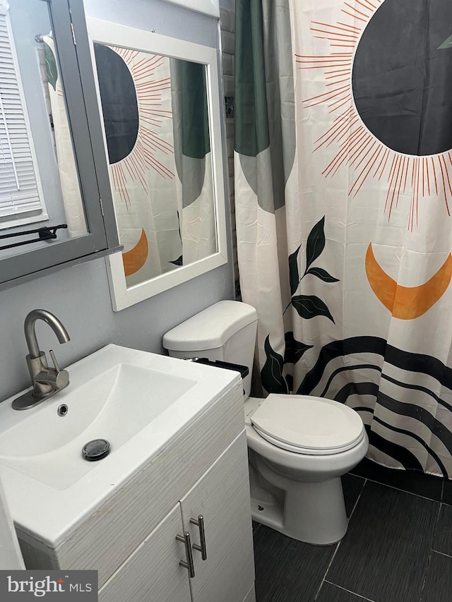 bathroom featuring tile patterned flooring, vanity, and toilet