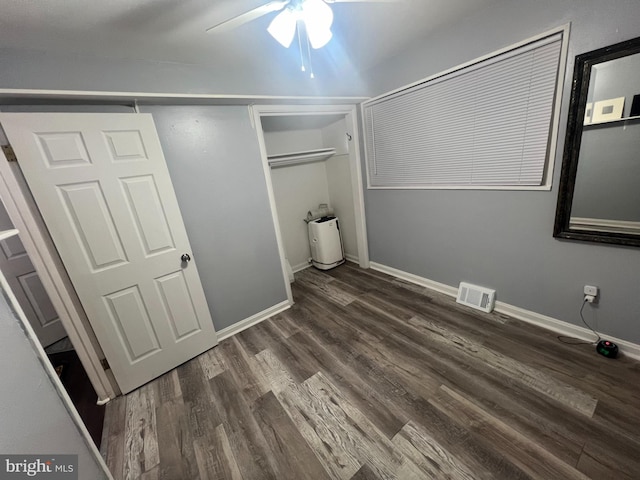 unfurnished bedroom with ceiling fan, a closet, and dark hardwood / wood-style floors