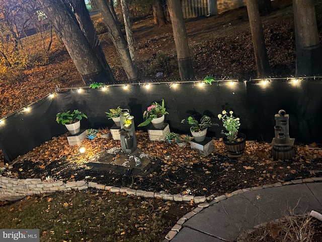 yard at night featuring a water view