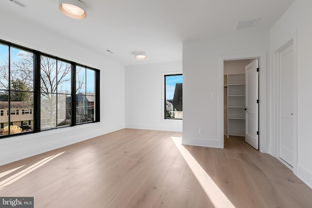 unfurnished room with light hardwood / wood-style flooring and a healthy amount of sunlight