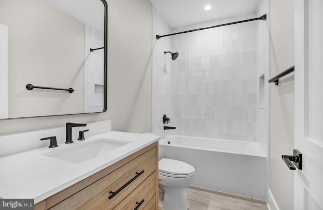 full bathroom featuring wood-type flooring, vanity, toilet, and tiled shower / bath combo