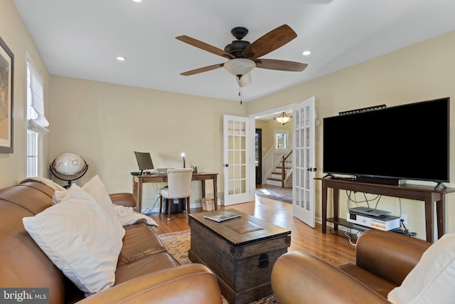 living room with ceiling fan, french doors, and light hardwood / wood-style floors