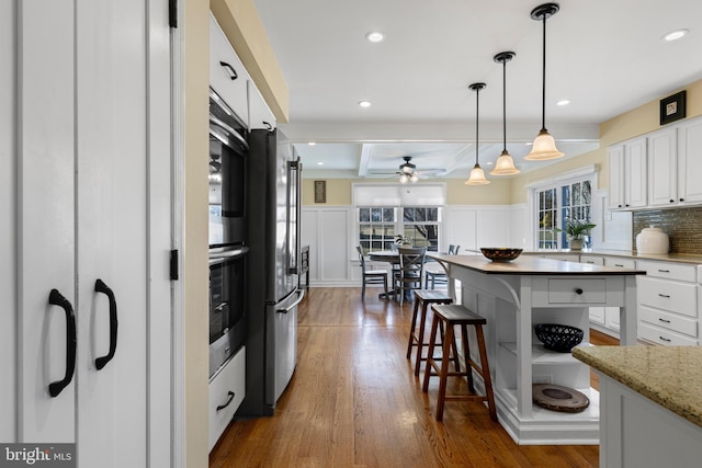 kitchen with white cabinetry, ceiling fan, appliances with stainless steel finishes, decorative light fixtures, and dark wood-type flooring