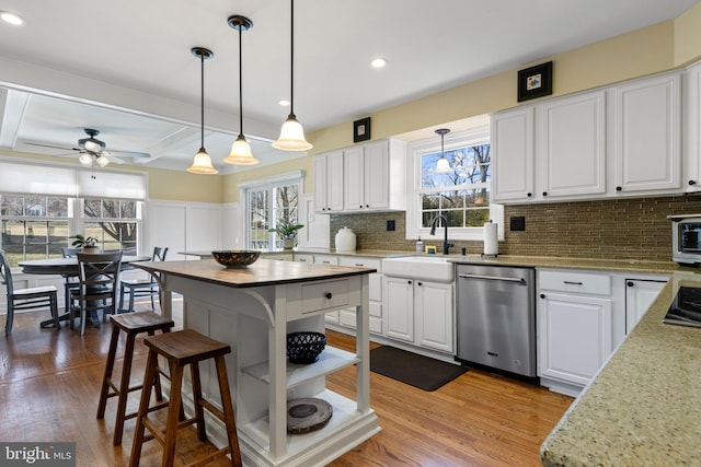 kitchen featuring white cabinetry, ceiling fan, tasteful backsplash, dishwasher, and pendant lighting