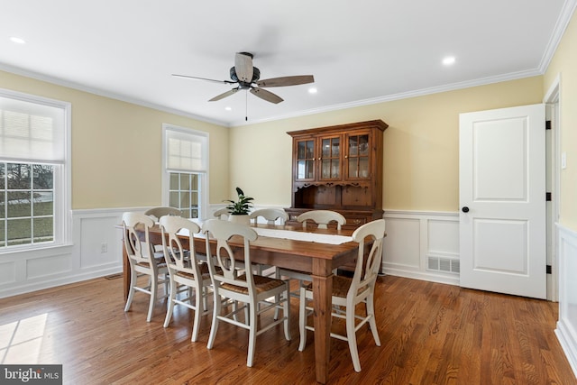 dining room featuring dark wood-type flooring, crown molding, and ceiling fan