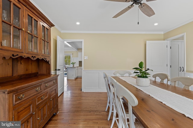 dining area with ceiling fan, ornamental molding, and light wood-type flooring