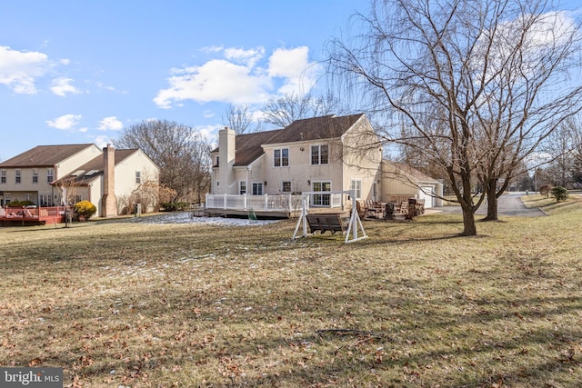 rear view of property with a lawn and a deck