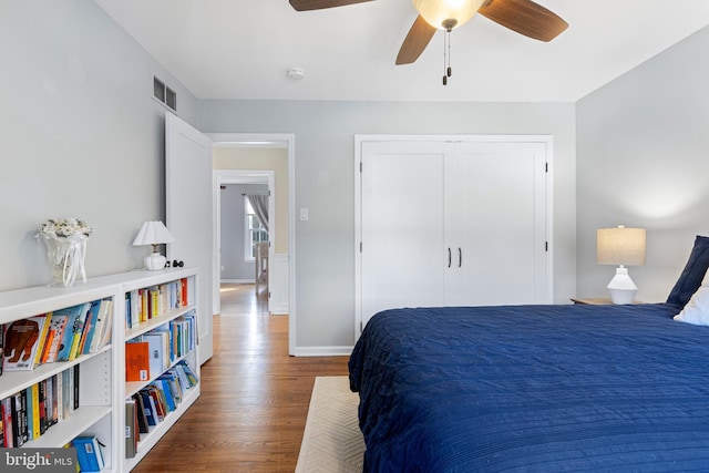 bedroom with ceiling fan, a closet, and dark wood-type flooring