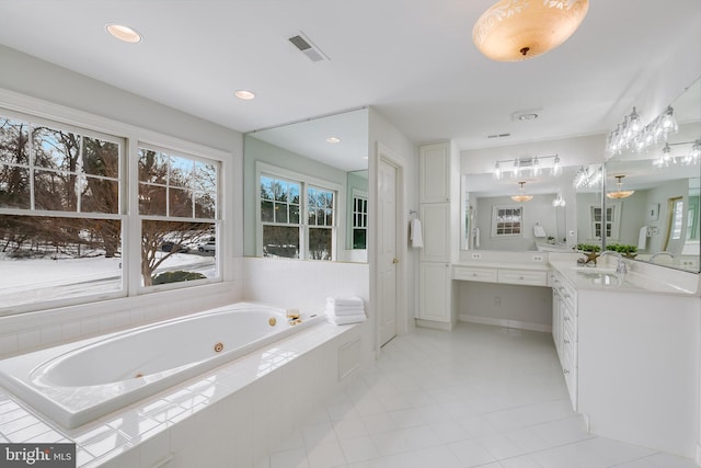 bathroom with vanity, tile patterned floors, and a relaxing tiled tub