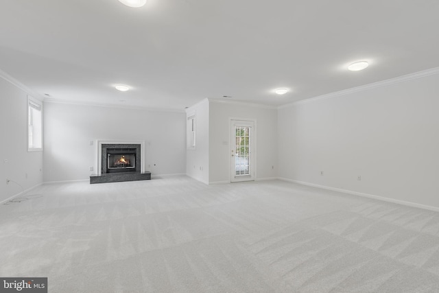 unfurnished living room featuring light colored carpet, crown molding, and plenty of natural light