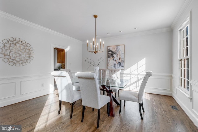 dining room featuring a notable chandelier, hardwood / wood-style floors, and crown molding