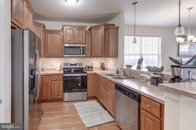 kitchen with sink, decorative light fixtures, light hardwood / wood-style floors, stainless steel appliances, and a chandelier