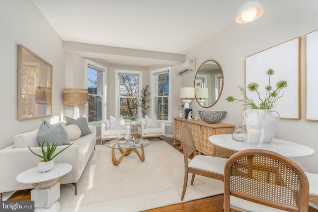 sitting room with hardwood / wood-style floors and a wall mounted AC