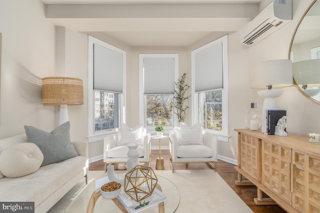 sitting room featuring an AC wall unit, hardwood / wood-style flooring, and a healthy amount of sunlight