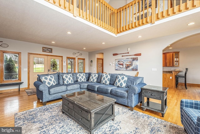 living room with light hardwood / wood-style floors, a textured ceiling, and french doors