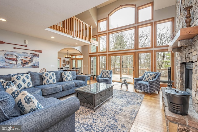 living room featuring a towering ceiling, light hardwood / wood-style flooring, and a notable chandelier