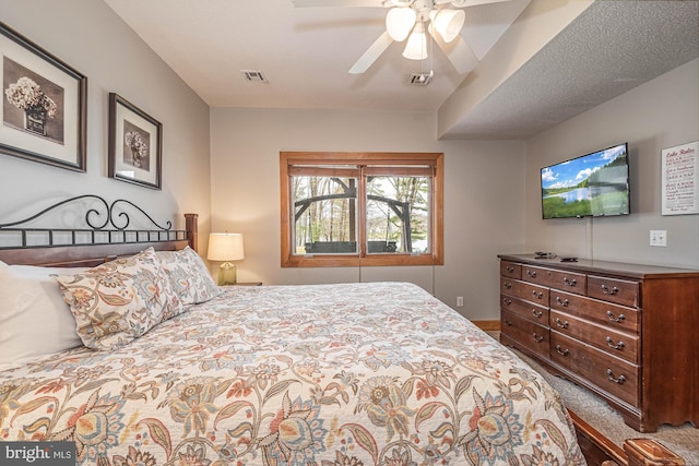 bedroom with carpet, a textured ceiling, and ceiling fan