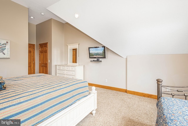 bedroom with carpet flooring and lofted ceiling